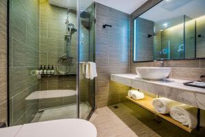 深圳Sky Hotel - Shenzhen Luohu Sungang BaoNeng Center的一间带水槽和玻璃淋浴的浴室