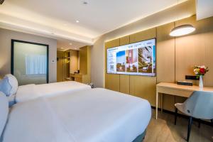 深圳Sky Hotel - Shenzhen Luohu Sungang BaoNeng Center的酒店客房设有两张床和投影屏幕