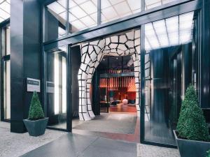 柏林铂尔曼柏林施维泽霍夫酒店的走廊上树木的建筑物入口