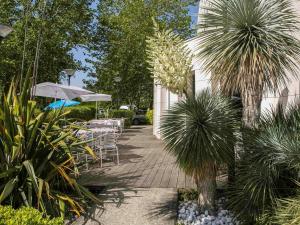 梅里尼亚克波尔多机场宜必思快捷酒店的一个带桌椅和遮阳伞的庭院