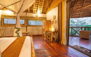 KatokeEmbogo Safari Lodges的一间卧室配有一张床、一张桌子和一个窗户。