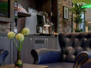 蒂宾根ibis Styles Tuebingen的一间配有沙发和一张带花瓶的桌子的餐厅