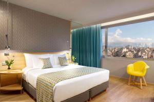 雅典大雅典温德姆酒店的酒店客房设有一张床和一个大窗户