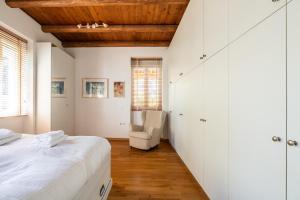 雅典Athenian 2BR Cottage with Garden & BBQ near Metro的白色卧室配有床和椅子