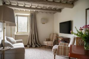 新吉蒂诺瓦达恩Il Borro Relais & Châteaux的客厅配有沙发、两把椅子和电视