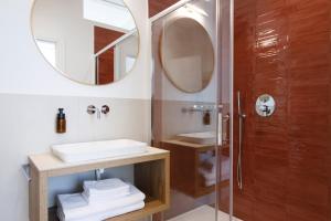 特伦托Electric Rooms & Suites的带淋浴、盥洗盆和镜子的浴室