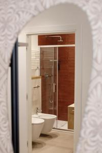 特伦托Electric Rooms & Suites的带淋浴、卫生间和盥洗盆的浴室