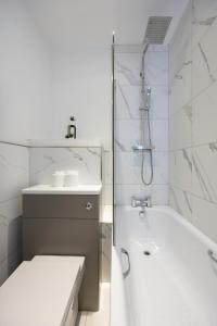 布莱顿霍夫Stunning Two Bedroom Brighton Penthouse的白色的浴室设有浴缸和水槽。