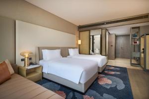 西安西安高新洲际酒店的酒店客房,设有两张床和一张沙发