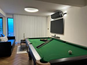 提比里亚מבית תכלת בית של חופש Allentown 21 אלנטאון 21的客厅设有台球桌和电视。