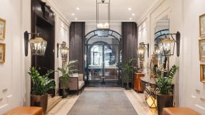 巴黎巴黎香榭丽舍大街兰卡斯特酒店的走廊上种有盆栽植物,门上有一扇门