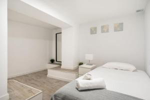 马德里Charming flat in Madrid-Rio的白色卧室配有床和镜子