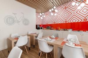 帕尔梅拉Porta da Arrábida Suites的一间带桌子和白色椅子的用餐室