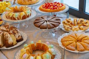 切塞纳蒂科Hotel Atlas的盘子里放满了蛋糕和糕点的桌子