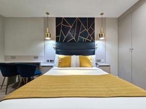 伦敦NOX Hyde Park的一间卧室配有一张带黄色枕头的大床