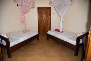 MasindiNew Court View Hotel的配有窗帘的客房内的两张床