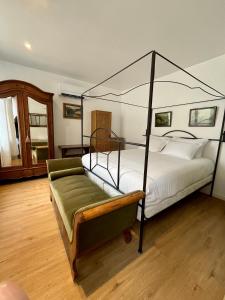 图尔昆Maison Georges的一间卧室配有天蓬床和长凳