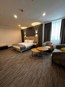 伊斯坦布尔VPLUS HOTEL的酒店客房配有床、沙发和桌子。