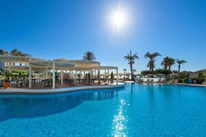 法里拉基罗德斯帕拉蒂姆休闲及健康酒店的一个带桌椅的大型蓝色游泳池
