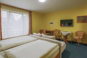 吕贝克理想酒店的酒店客房设有两张床和一张桌子。