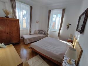 科米扎APARTMAN RIVA 2的一间卧室设有两张床、一张桌子和两个窗户。