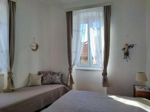 科米扎APARTMAN RIVA 2的一间卧室设有两张床和窗户。