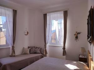 科米扎APARTMAN RIVA 2的一间卧室设有两张床和两个窗户。