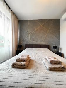 斯诺科Stylowy Apartament w Serocku的一间卧室配有一张床,上面有两条毛巾