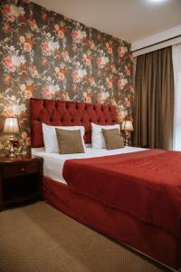 巴库Address Boutique Hotel Baku的一间卧室配有一张大床和红色床头板