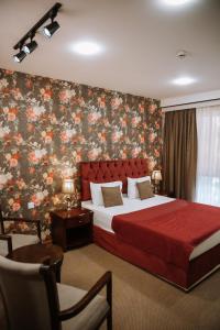 巴库Address Boutique Hotel Baku的一间卧室配有一张带花卉壁纸的大床
