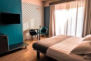 卡萨莱蒙费拉托商务酒店的一间卧室配有一张床和一张桌子及椅子