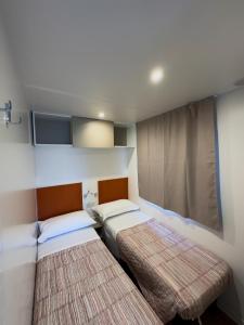 马尔孔滕塔威尼斯共和国露营旅馆的一间卧室设有两张床,其中设有窗户。