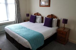 圣赫利尔泽西莫文酒店之高地公寓的一间卧室配有一张带紫色枕头的大床