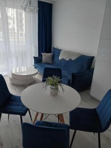 新苏尔Apartament MajaHouse的客厅配有蓝色的沙发、桌子和椅子