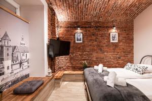 克拉科夫DIETLA 99 APARTMENTS - IDEAL LOCATION - in the heart of Krakow的一间带砖墙和沙发的客厅