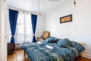 巴黎GuestReady - Luxury Living near Panthéon的一间卧室配有一张带蓝色棉被的床