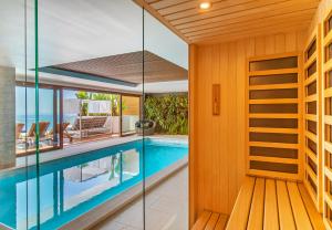 杜布罗夫尼克Dubrovnik luxury apartments的一座玻璃墙房子内的游泳池