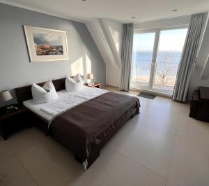 德兰斯克德兰斯克沙滩酒店的一间卧室设有一张大床和一个大窗户