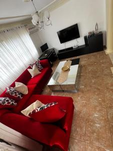 圣地亚哥洛斯卡巴Casa Deisy的客厅配有红色沙发和电视