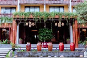 会安Little Gem. An Eco-Friendly Boutique Hotel & Spa的一群红色花瓶在建筑物前