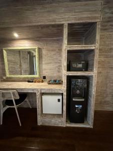 蓝梦岛The Niti Hut's Lembongan的小客房设有带水槽的书桌和冰箱。