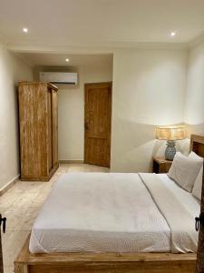 乌布蜜月旅馆的一间卧室配有一张大床和一个木制橱柜