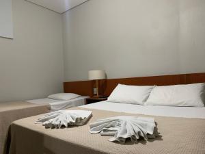 Três PontasHotel Ouro Verde的卧室内的两张床,配有毛巾