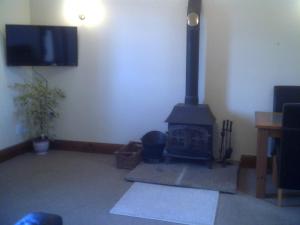 兰卡斯特Knotts Farm Holiday Cottages的客厅设有壁炉和平面电视。