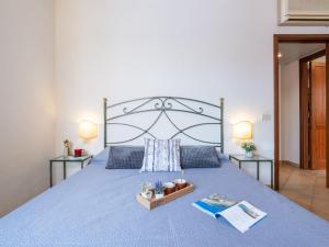 NotteriHoliday Home Carlo-4 by Interhome的一间卧室配有一张大蓝色的床和两张桌子