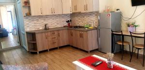 第比利斯tamunas apartment的厨房配有木制橱柜和冰箱。