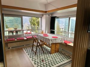 马里尔伊瓦Bellavista Marilleva 1400 - Val di Sole的客房设有桌子和带窗户的阳台