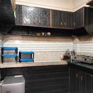 阿尔莫拉Bhanu Village House的厨房配有黑色橱柜和蓝色凳子