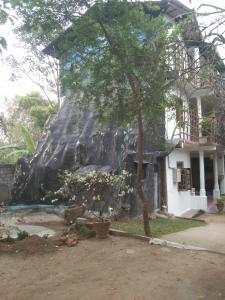 波隆纳鲁沃Suneetha Hotel的前面有假瀑布的房子