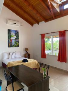 Puerto LibertadHotel Puerto Libertad - Iguazú的一间卧室配有一张床、一张桌子和一个窗户。